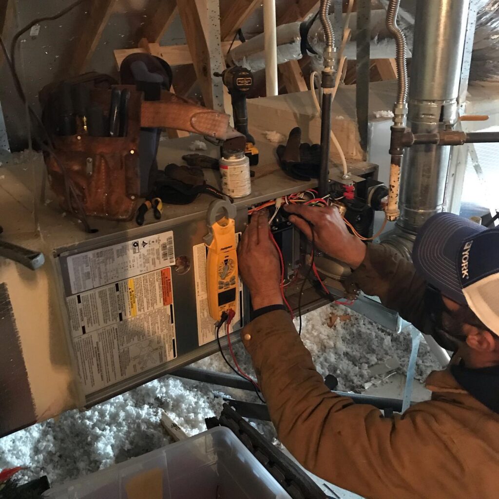 Heating system repair. HVAC technician diagnosing a furnace with a multimeter. Heating maintenance in Southlake, TX. Furnace service.