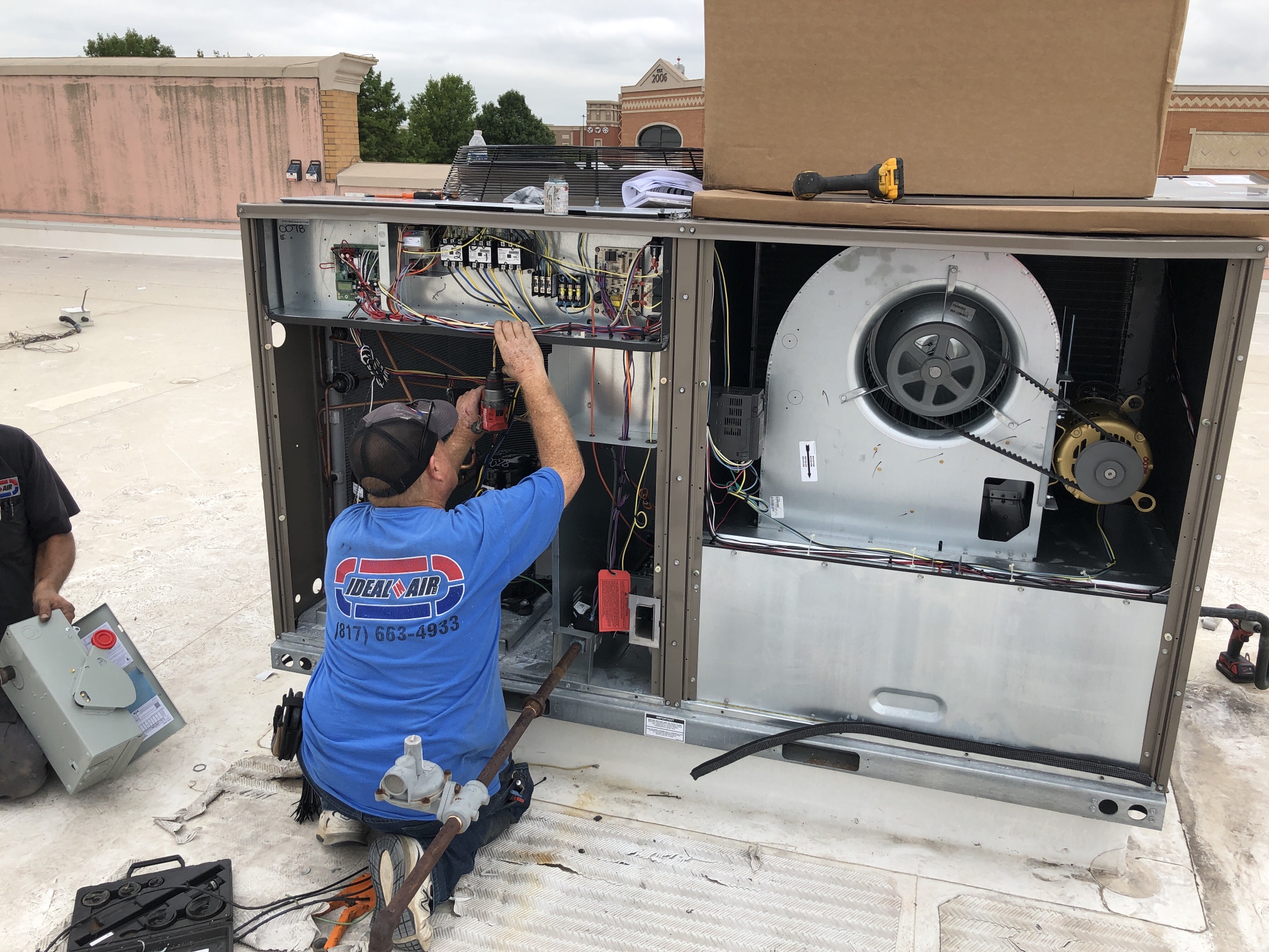 HVAC technician repairs a Commercial HVAC unit on a rooftop. Commercial HVAC maintenance in Southlake, TX.